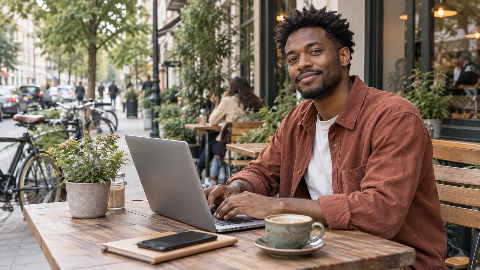 A man working at a street-side cafe restyled as a square-face illustrated avatar — before editing